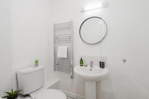 a white bathroom with a toilet and a sink at Modern 2 Bed Apt with Roof Terrace - Ecclesall Rd - Now Hosted by StayHostSave in Sheffield