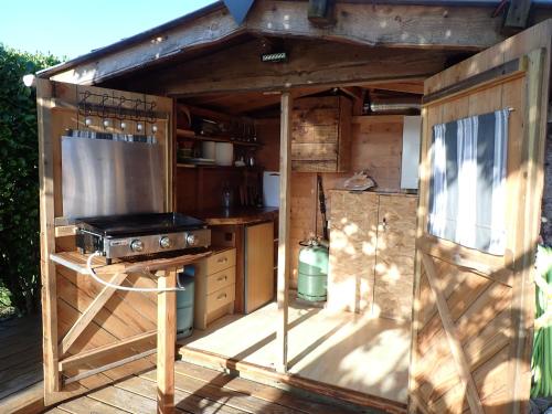 une cuisine extérieure avec un grill et une cuisinière dans l'établissement Location vacances proche mer, à Cléder