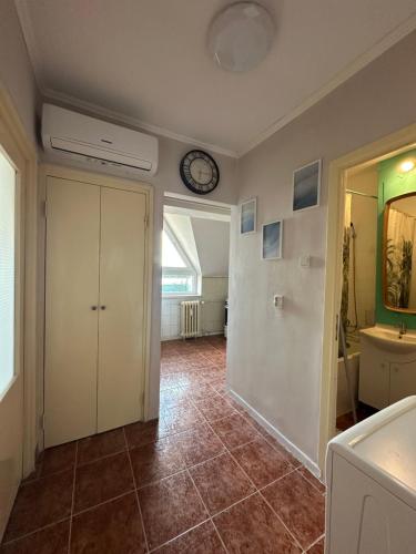 a room with a clock on the wall and a bathroom at Garsonieră lângă Prefectură in Craiova