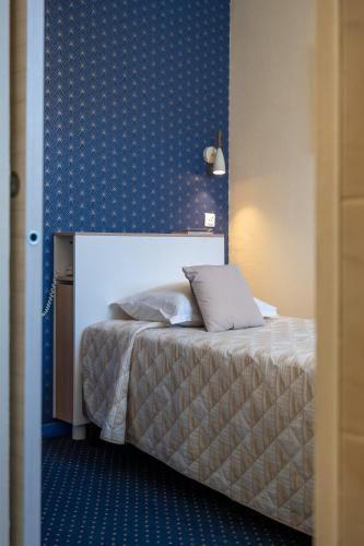 Katil atau katil-katil dalam bilik di Logis Hôtel Central