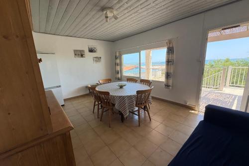 une salle à manger avec une table et des chaises et un balcon dans l'établissement The waterfront, à Frontignan