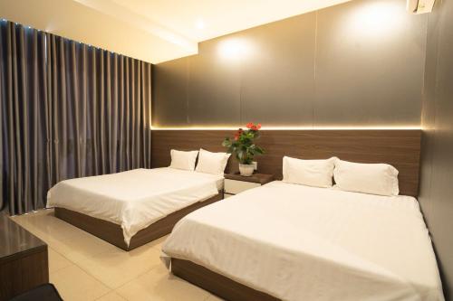 a hotel room with two beds and a flower arrangement at Ngoc Se Hotel in Pleiku