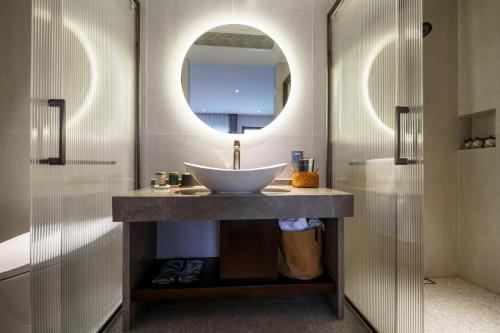 a bathroom with a sink and a mirror at 大理沙溪云喜七月精品客栈 Shaxi Ancient Town Yunxi Qiyue Guesthouse in Jianchuan