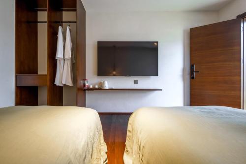 a hotel room with a bed and a flat screen tv at 大理沙溪云喜七月精品客栈 Shaxi Ancient Town Yunxi Qiyue Guesthouse in Jianchuan