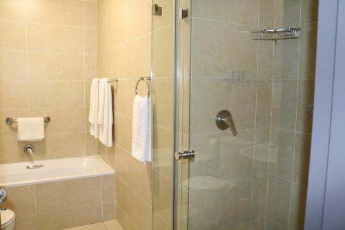 a bathroom with a shower with a glass door at Melrose Corner Self-Catering Hotel Apartments in Johannesburg