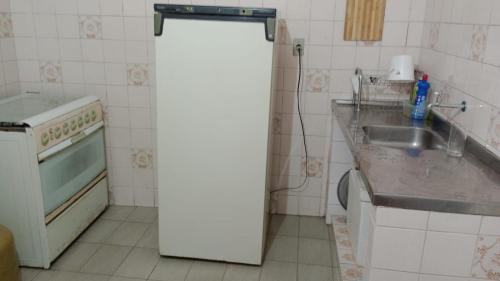 einen weißen Kühlschrank in einer Küche mit Spüle in der Unterkunft Casa no Bairro da Prata, para até 8 pessoas, 150mt do PP in Campina Grande