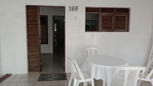 einen weißen Tisch und Stühle in einem weißen Zimmer in der Unterkunft Casa no Bairro da Prata, para até 8 pessoas, 150mt do PP in Campina Grande