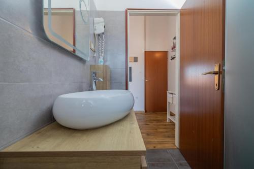 a bathroom with a white sink on a wooden counter at Casa Botin in Rovinj