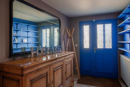 La salle de bains est pourvue d'un miroir et d'une porte bleue. dans l'établissement Les Flots - Wi-Fi, TV, Garages, Central, à Pornic