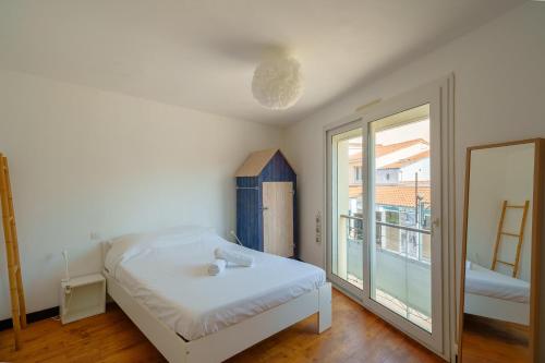 une chambre avec un lit et une grande fenêtre dans l'établissement Les Flots - Wi-Fi, TV, Garages, Central, à Pornic