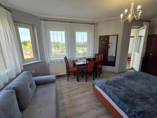 a bedroom with a bed and a table and chairs at Apartamenty i pokoje Sosnowa 4 Dębki in Dębki