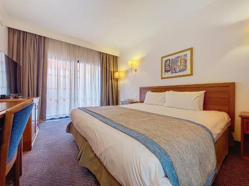 a hotel room with a large bed and a window at Vivaldi Hotel in St Julian's