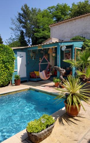 une maison bleue avec une piscine et des plantes dans l'établissement Le Mazet des Beaujots, à Monteux