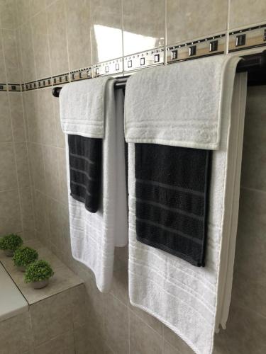 three towels hanging on a rack in a bathroom at Brackenfell self catering accommodation in Brackenfell
