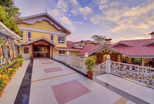 a house with a white rail fence and a balcony at Mayfair Darjeeling in Darjeeling