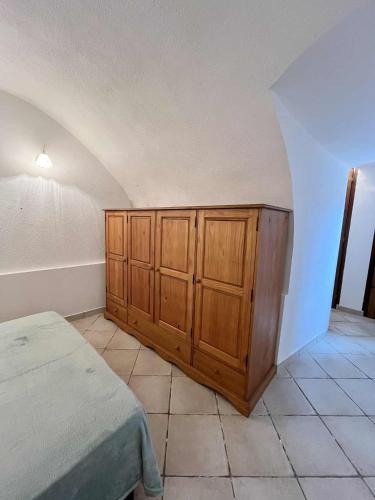 - une chambre avec un lit et des placards en bois dans l'établissement Appartement de village à Aregno, à Aregno