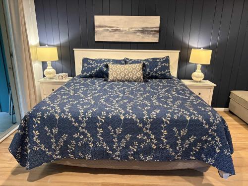a bedroom with a bed with a blue comforter and two lamps at Shanty Creek, Condo, Golf ,Sleeps 4, Pets welcome! in Bellaire