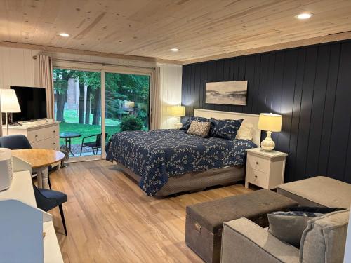 a bedroom with a bed and a living room at Shanty Creek, Condo, Golf ,Sleeps 4, Pets welcome! in Bellaire