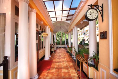 a hallway with columns and a clock in a building at Mayfair Darjeeling in Darjeeling