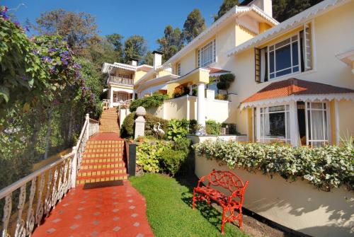 a house with a red bench in front of it at Mayfair Darjeeling in Darjeeling
