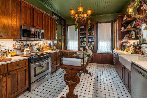 a large kitchen with wooden cabinets and a chandelier at The Nook and Key in Anna