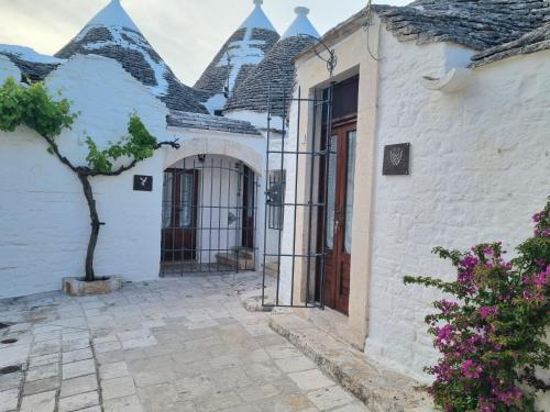 a white building with a tree in front of it at Romantic Corner in Alberobello
