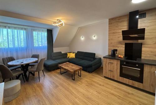 a living room with a couch and a table at Charming Apartments - Ski Arena Szrenica in Szklarska Poręba