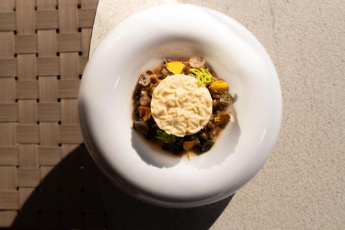 a white plate of food with beans and ice cream at Santo Mine Oia Suites in Oia