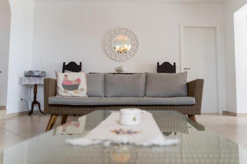 ein Wohnzimmer mit einer Couch und einem Glastisch in der Unterkunft Casa das Malvas in Porto Santo