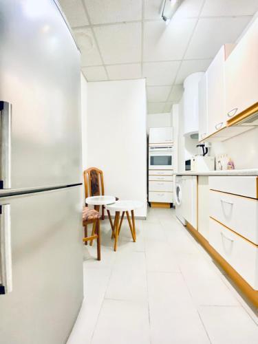 a kitchen with white cabinets and a refrigerator at Sweet 3-Bedroom shared Apartment in a Quiet Neighborhood in Vienna