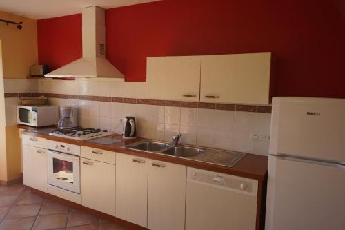 une cuisine avec un évier et un réfrigérateur blanc dans l'établissement Ti Bras Gite de Saint Guénolé, à Trévou-Tréguignec