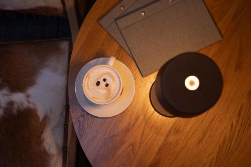 a cup of coffee on a table with a candle at Hotel Faaborg Fjord in Fåborg