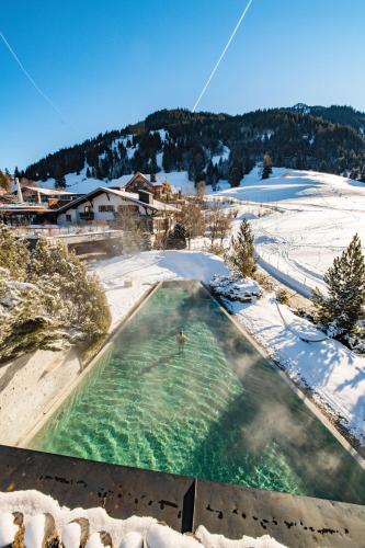 a swimming pool in the middle of a snow covered yard at Jungbrunn Der Gutzeitort in Tannheim