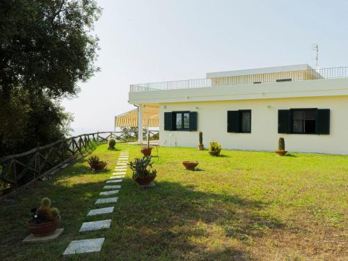 a house with a garden with potted plants in the yard at Villa Andrea in città dell'arcomagno in San Nicola Arcella