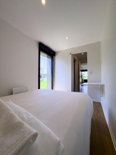 a bedroom with a large white bed with a window at EcoCampus du Comminges in Gourdan-Polignan