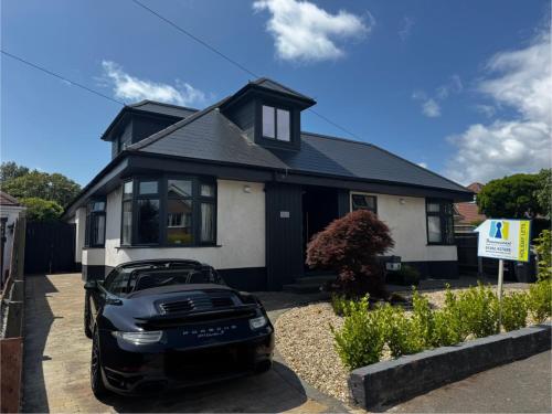 a black car parked in front of a house at BOURNECOAST - Bungalow-Garden-BBQ hut-WIFI- HB6339 in Bournemouth