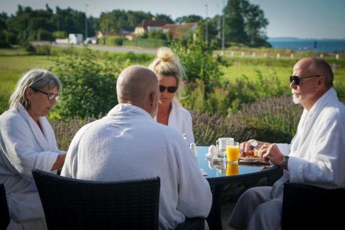 a group of people sitting around a table at Hotel Faaborg Fjord in Fåborg