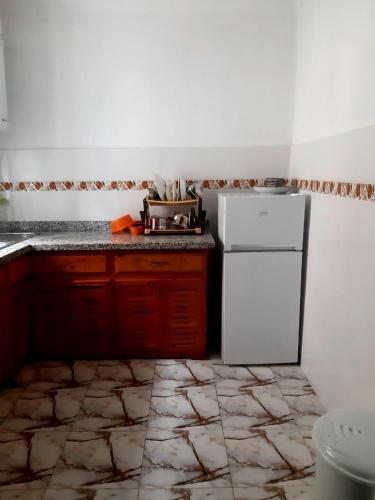 a kitchen with a white refrigerator and a tile floor at Dar yahya in Chefchaouene