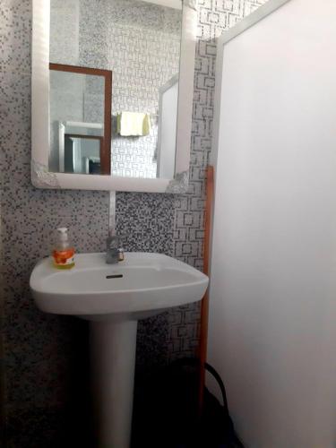 a bathroom with a white sink and a mirror at Dar yahya in Chefchaouene