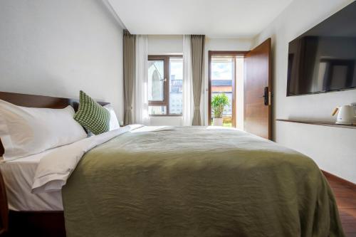 a bedroom with a large bed and a window at 大理沙溪云喜七月精品客栈 Shaxi Ancient Town Yunxi Qiyue Guesthouse in Jianchuan
