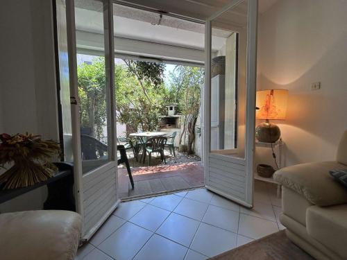 - un salon avec une porte s'ouvrant sur une terrasse dans l'établissement SP000-011 Appartement 3 pièces 6 couchages SAINT PIERRE LA MER, à Saint Pierre La Mer