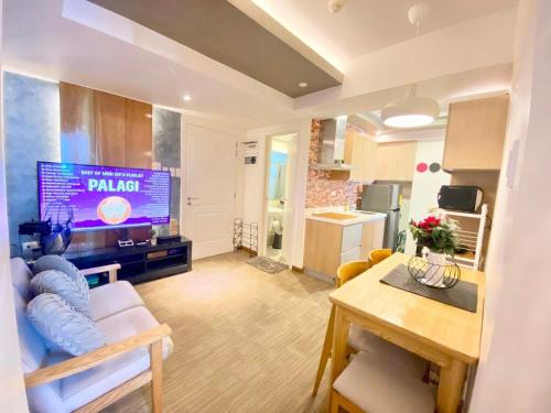 a living room with a couch and a table and a tv at Azure Cozy Hotel by CM staycation in Manila