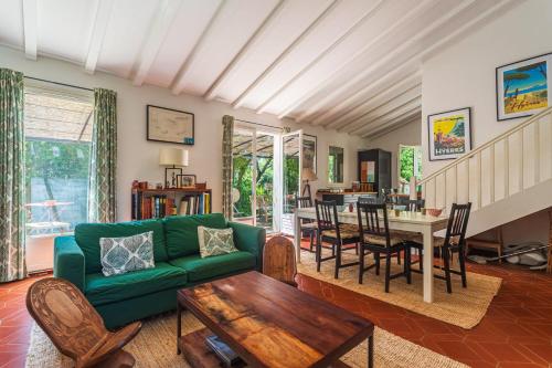 un salon avec un canapé vert et une table dans l'établissement Maison Lumière des Pins - Welkeys, à Hyères