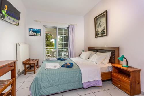 a bedroom with a large bed and a window at Melissa Gold Coast in Psakoudia