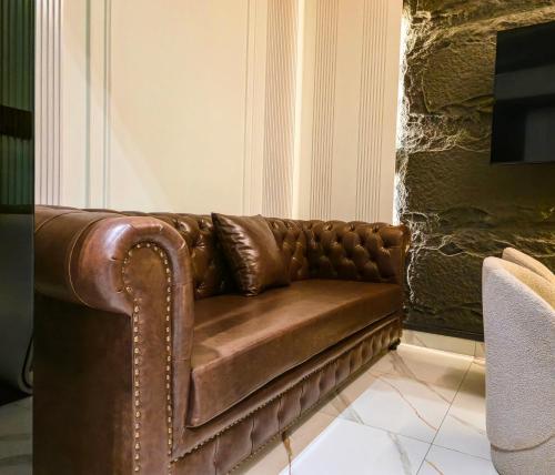 a brown leather couch sitting in a room at The White Suites in Karachi