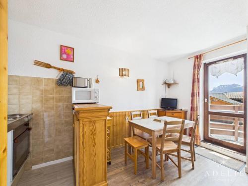une petite cuisine avec une table et un micro-ondes dans l'établissement Studio cabine 4/5 pers, balcon exposé sud, à 50m des pistes, parking inclus - FR-1-398-513, à La Rosière