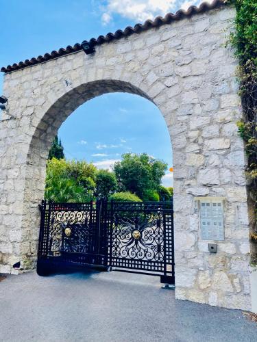an entrance to a stone archway with an iron gate at NICE luxury residence, Garden level with sea view and swimming pool, 2bedroom apartment of approximately 85 square meter and private garden in Nice