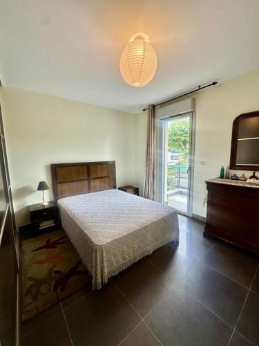 a bedroom with a bed and a sliding glass door at Apartment with sea view and access in LʼÎle-Rousse