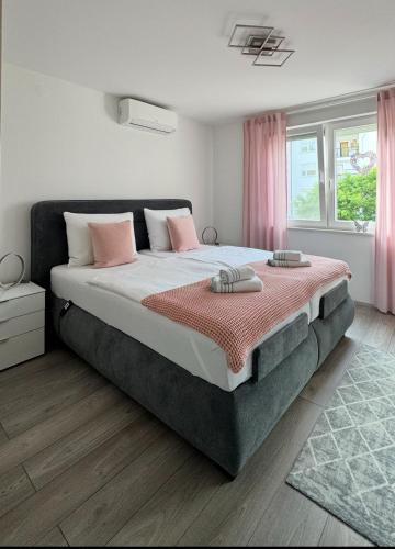 a bedroom with a large bed with pink curtains at Apartment Tomy in Rijeka