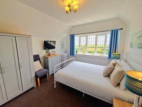 a bedroom with a white bed and a window at The Kensington in Great Yarmouth